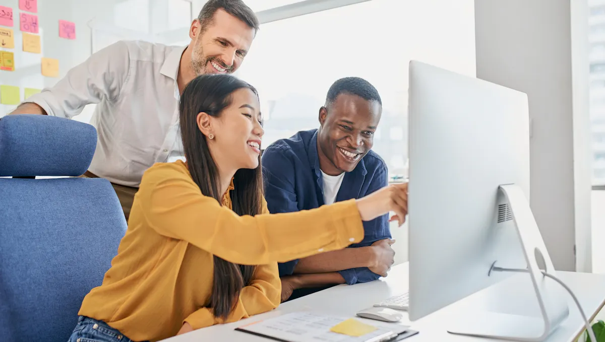 Three colleagues working at office on computer